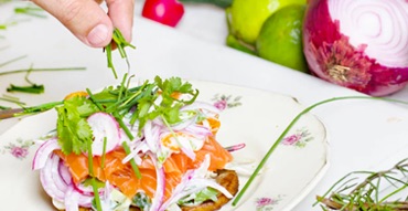 Smoked salmon, onions, and greens atop a slice of bread